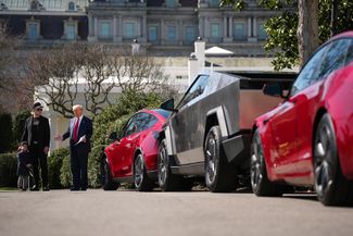 Президент США Дональд Трамп, старший советник Белого дома, генеральный директор Tesla и SpaceX Илон Маск и его сын Икс на Южной лужайке Белого дома 11 марта 2025 года. Трамп, стоя рядом с автомобилями Tesla Model Y, Cyber ​​Truck и Model S, выступил против бойкота компаний Маска и пообещал купить автомобиль Tesla в качестве «демонстрации доверия и поддержки»