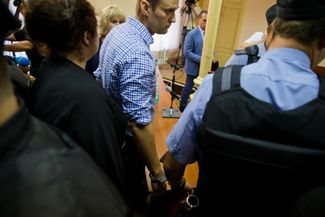 When Navalny became the generally accepted leader of the Russian opposition, the Investigative Committee opened various criminal cases against him. The first case went to court in mid-2013. Navalny and a businessman from Kirov, Pyotr Ofitserov, were accused of embezzlement on charges that Navalny and his supporters said were trumped up. Ofitserov refused to testify against Navalny. Both men were found guilty and sentenced to four and five years in prison, respectively. After the verdict was announced, guards removed the defendants from the courthouse. July 18, 2013. 